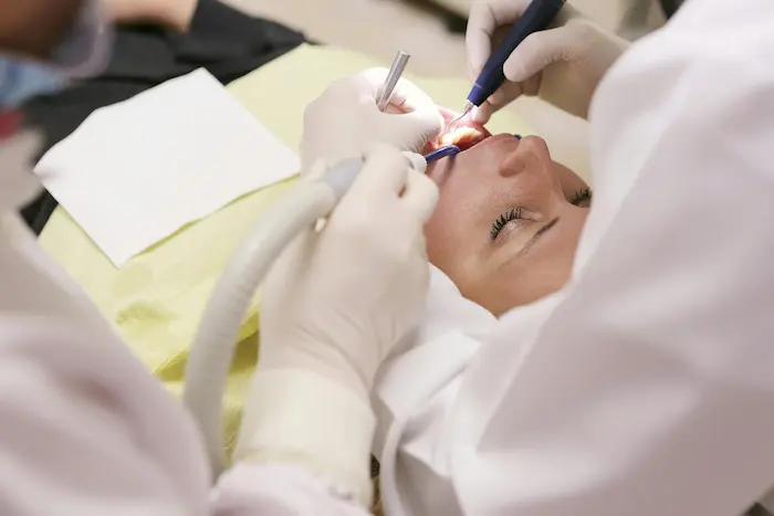 Dentista realizando destartraje dental con herramientas de precisión