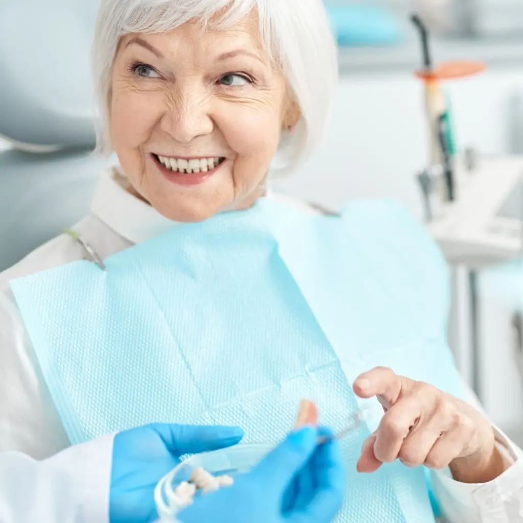 Odontóloga explicando un plan de tratamiento dental a una paciente sonriente usando una tablet en la clínica.